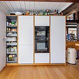 Geöffneter Vorratsschrank mit Innenauszügen, maßgefertigt von der woodendesign Möbeltischlerei für den Bestand im Fachwerkhaus.