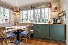 Landhausküche in Salbeigrün, Hamburg Altona | maßgefertigt von der Möbeltischlerei woodendesign – harmonisches Zusammenspiel von Holz, Grün und natürlichem Licht in der Essecke