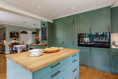 Landhausküche in Salbeigrün, Hamburg Altona | maßgefertigt von der Möbeltischlerei woodendesign – Kücheninsel mit Stauraum und Küchenhochschränken