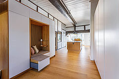Einbauschränke im Flur mit Sitznische und ausgezogenem Schubkasten, Blick zur Kücheninsel