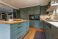 Landhausküche in Salbeigrün, Hamburg Altona | maßgefertigt von der Möbeltischlerei woodendesign – harmonisches Zusammenspiel von salbeigrüner Lackierung, Eiche Massivholz & weißer Keramik