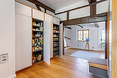 Geöffnete Vorratsschränke im Einbau, weiß lackiert mit Eichenrahmen, im Fachwerk-Flur