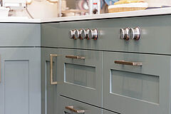 Landhausküche in Salbeigrün, Hamburg Altona | maßgefertigt von der Möbeltischlerei woodendesign – Gaggenau Kochfeld - Herdknebel in Frontblende integriert