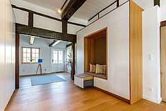 Sitznische im Einbau mit Holzlamellen und Kissen, moderne Einbauten im Fachwerkhaus