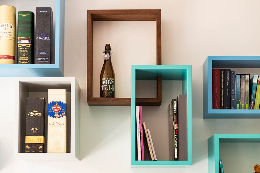 Wandregale als farbige Boxen in Türkis, Weiß und Nussbaum; Bücher und Deko locker arrangiert, schwebende Wirkung, leichte Komposition. Aktuelles – Trends – News im November 2025 | Möbeltischlerei woodendesign | Tischlerei Möbeltischler Möbelmanufaktur Hamburg