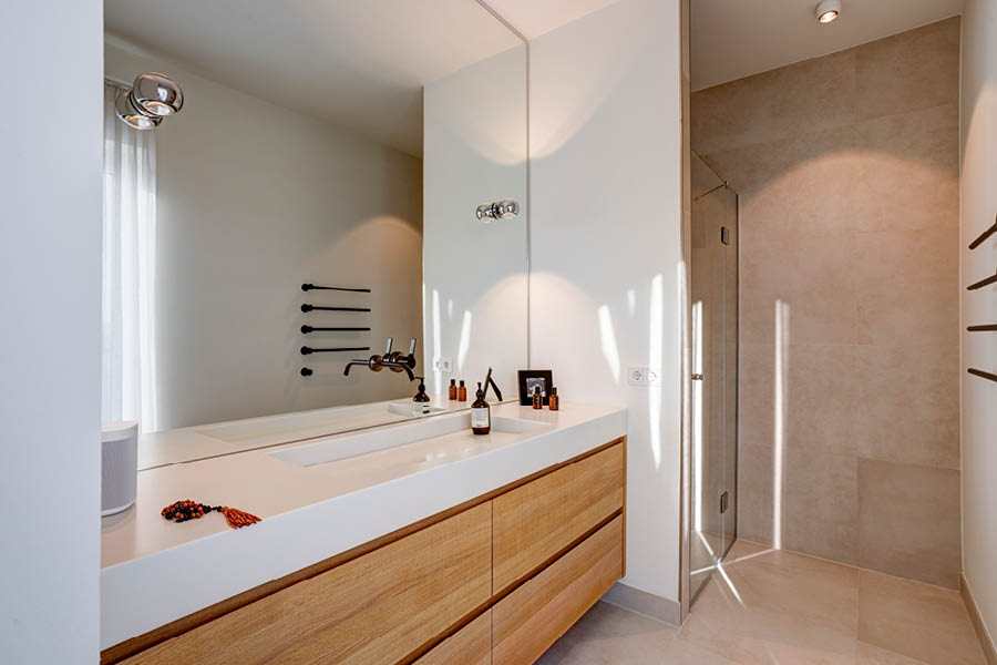 Minimalistischer Doppelwaschtisch mit langen Eichenfronten und weißer Waschtischplatte; große Spiegelwand, bodengleiche Dusche. Holz im Badezimmer | Aktuelles – Trends – News im Dezember 2025 | Möbeltischlerei Tischlerei Möbeltischler Möbelmanufaktur Hamburg