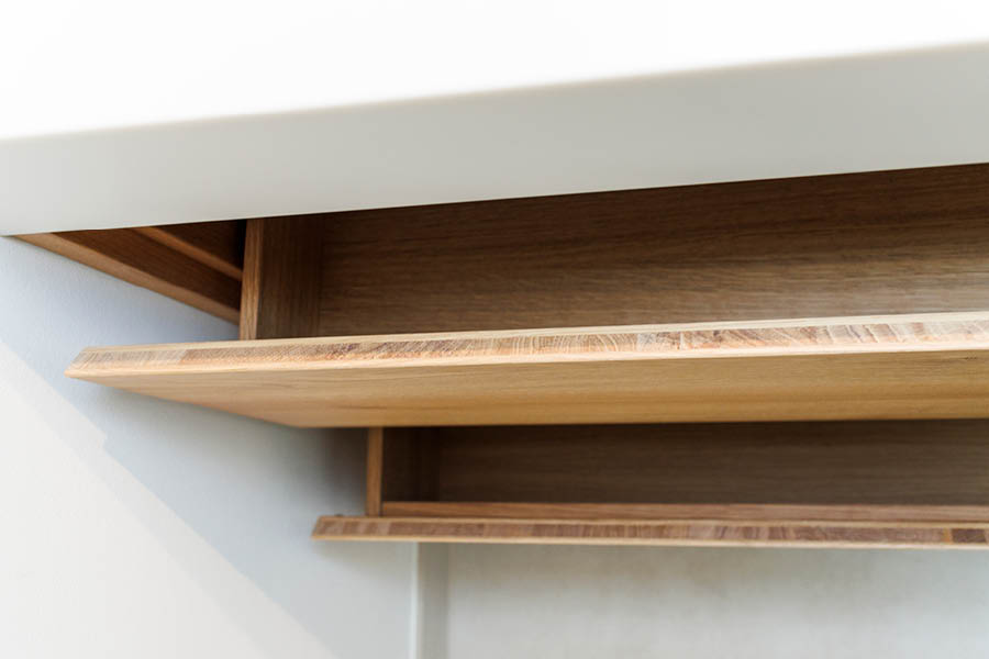 Detail unter der Waschtischplatte: innenliegendes Eichen-Ablagebrett, geölte Kanten, klare Linienführung für griffbereiten Stauraum. Holz im Badezimmer | Aktuelles – Trends – News im Dezember 2025 | Möbeltischlerei Tischlerei Möbeltischler Möbelmanufaktur Hamburg