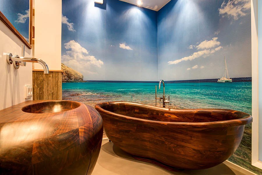 Holzbadewanne mit passendem Waschtisch vor maritimer Wandgrafik; stimmungsvolle Badatmosphäre, warmes Materialbild. Holz im Badezimmer | Aktuelles – Trends – News im Dezember 2025 | Möbeltischlerei Tischlerei Möbeltischler Möbelmanufaktur Hamburg
