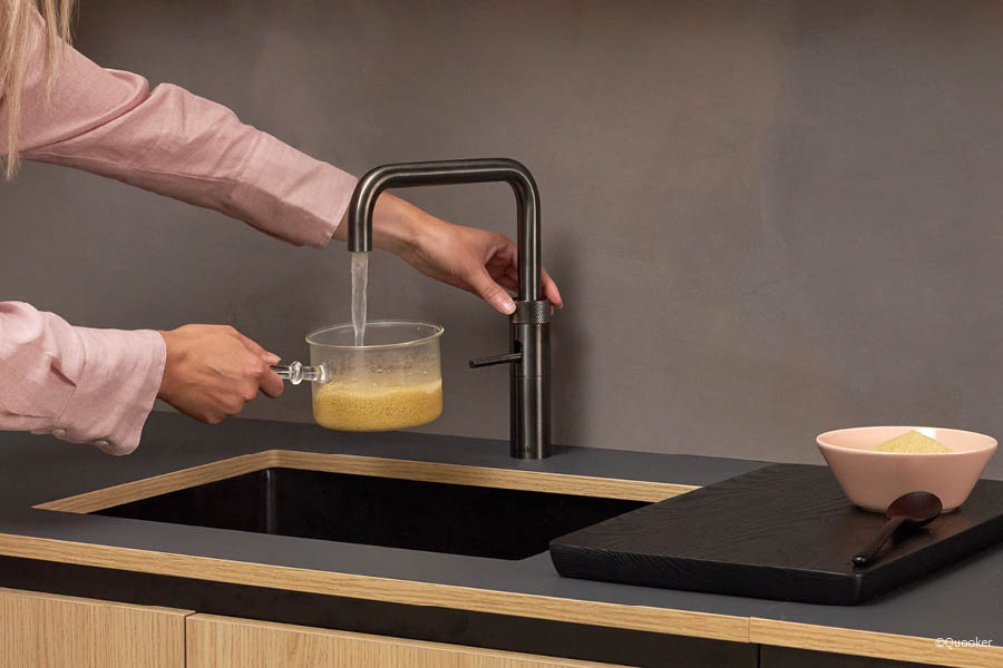 Armatur mit integriertem Heißwassersystem beim Befüllen eines Topfes in moderner Küche | Aktuelles – Trends – News im März 2026 | Möbeltischlerei Tischlerei Möbeltischler Möbelmanufaktur Hamburg