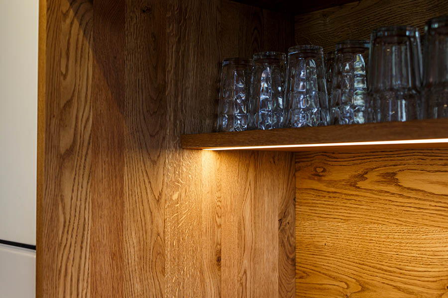 Offenes Regal aus Holz mit integrierter LED-Beleuchtung für gezielte Ausleuchtung von Gläsern – Lichtplanung Küche | Aktuelles – Trends – News im April 2026 | Möbeltischlerei Tischlerei Möbeltischler Möbelmanufaktur Hamburg
