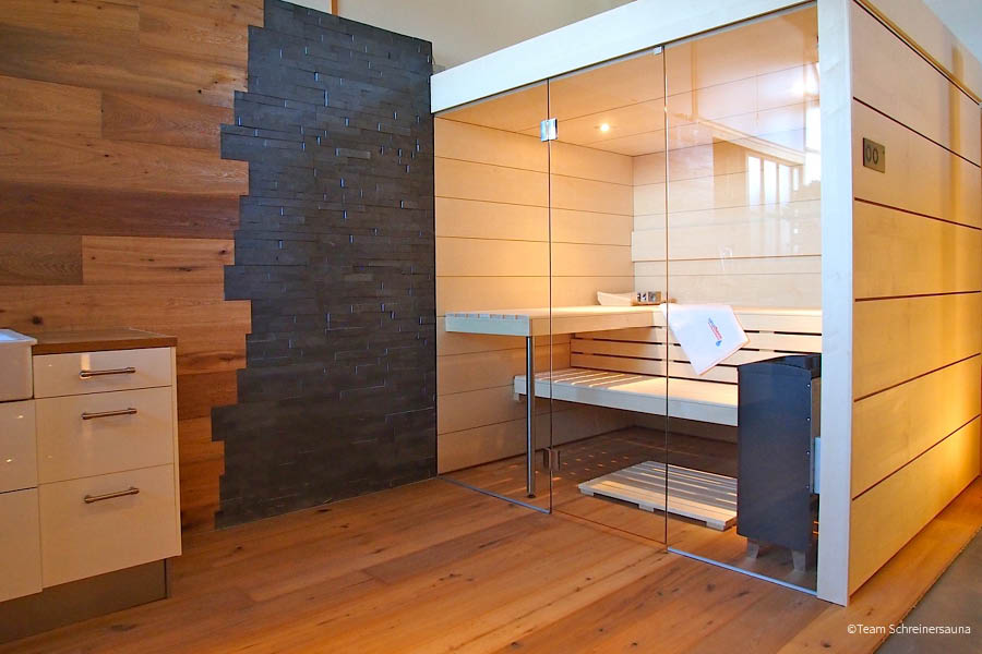 Individuell integrierte Sauna mit Glasfront, hellen Holzbänken sowie Wandgestaltung aus Holz und Naturstein | Sauna Wärmekabine Infrarot | Aktuelles – Trends – News im Juli 2026 | Möbeltischlerei Tischlerei Möbeltischler Möbelmanufaktur Hamburg