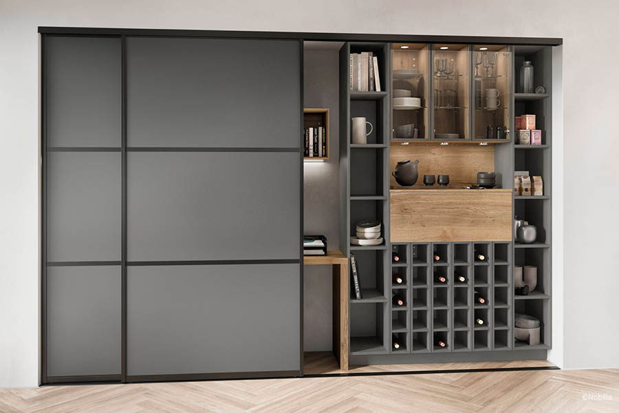 Möbelwand mit großflächigen Schiebetüren vor integriertem Stauraum, Vitrine und Weinregal | Schiebetüren als Raumtrenner | Aktuelles – Trends – News im September 2026 | Möbeltischlerei Tischlerei Möbeltischler Möbelmanufaktur Hamburg