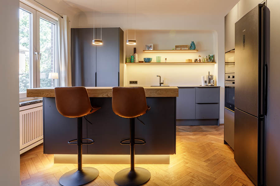 stimmungsvolle Atmosphäre durch indirekte Beleuchtung am Sockel | Kücheninseln, auch Küchenblock oder freistehende Kochinsel genannt, sind das Zentrum moderner Küchen. Die Möbeltischlerei woodendesign, Ihr Küchenexperte / Küchenprofi in Hamburg berät Sie gern.