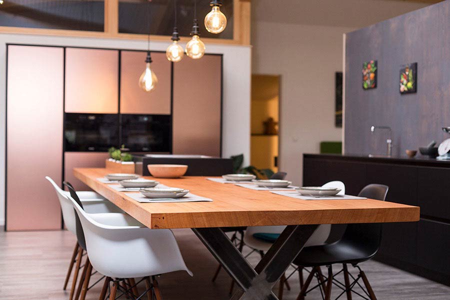 Küchenblock aus purem Holz mit integriertem Esstisch im Showroom der Möbelmanufaktur woodendesign für Ihren Beratungstermin