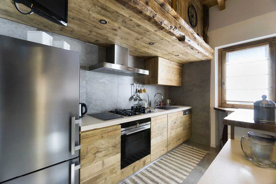 Vollholzküche mit Küchenzeile aus massivem Holz und Kühlschrank in Edelstahloptik