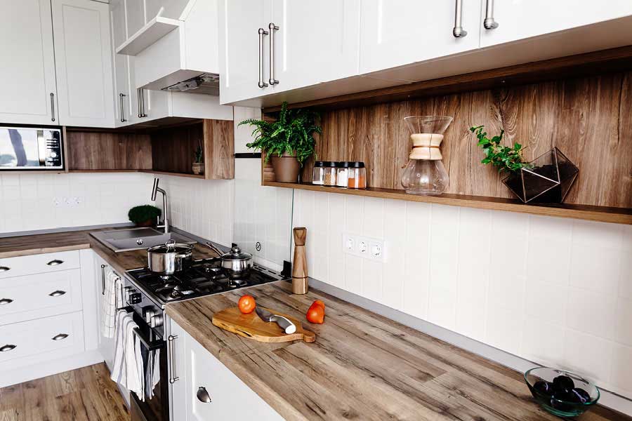 Massivholzküche mit hellen, weißen Küchenschrankfronten und Arbeitsplatte aus Naturholz | woodendesign feine Möbel