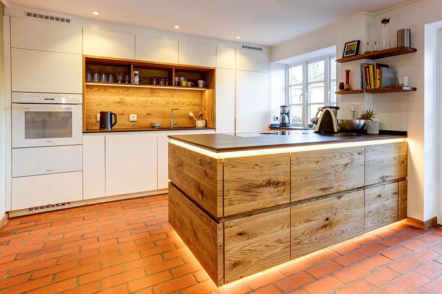 Massivholzküche geplant, designt und realisiert von woodendesign mit indirekter Beleuchtung, beleuchteten Schubladen und grifflosen Fronten
