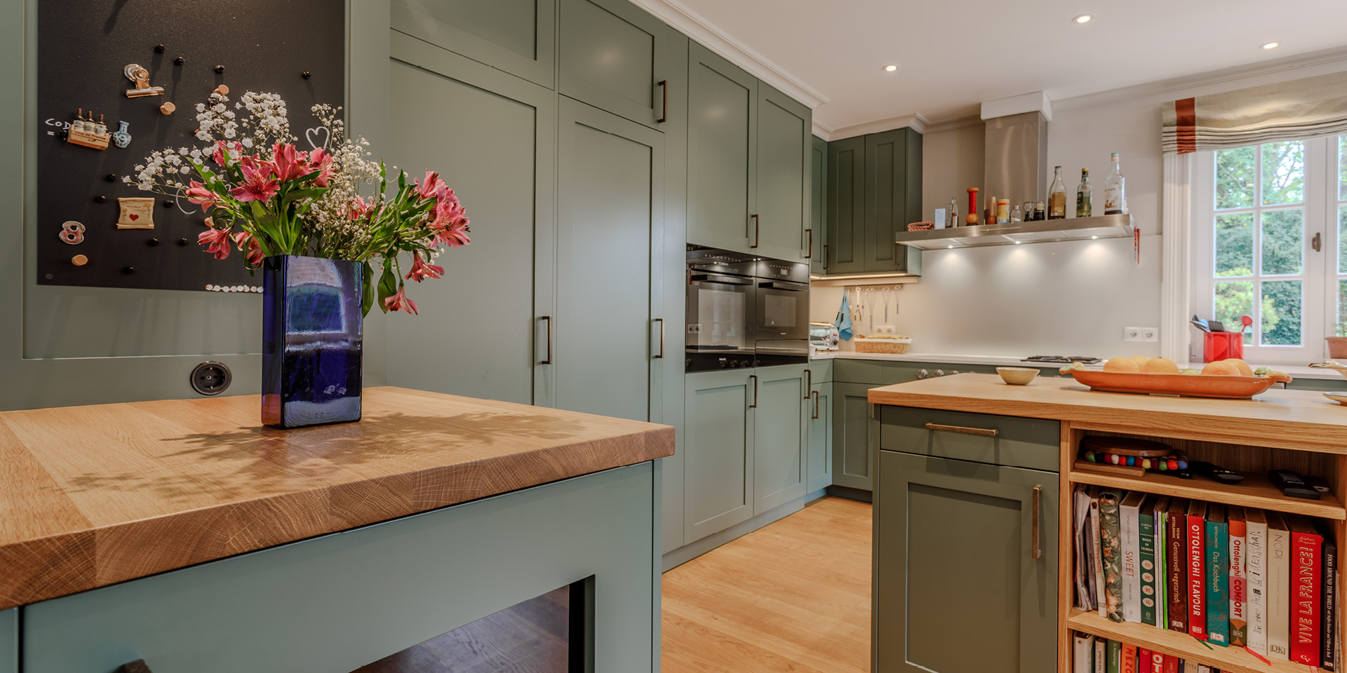 Landhausküche in Salbeigrün, Hamburg Altona | maßgefertigt von der Möbeltischlerei woodendesign – Gesamtansicht mit freistehender Kücheninsel, massiver Eichenarbeitsplatte und harmonischem Farbkonzept